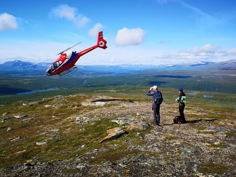 A helicopter flies over a vast landscape.