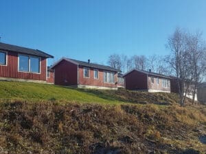 Rote Häuser am Hang unter blauem Himmel.