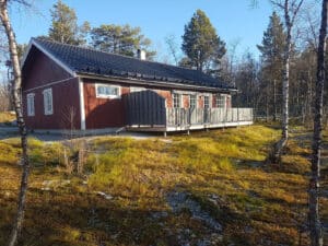 Hütte mit Veranda in bewaldeter Umgebung