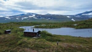 Hütte am Fluss mit Bergen im Hintergrund