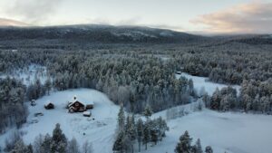 Schneebedeckte Landschaft mit rotem Holzhaus