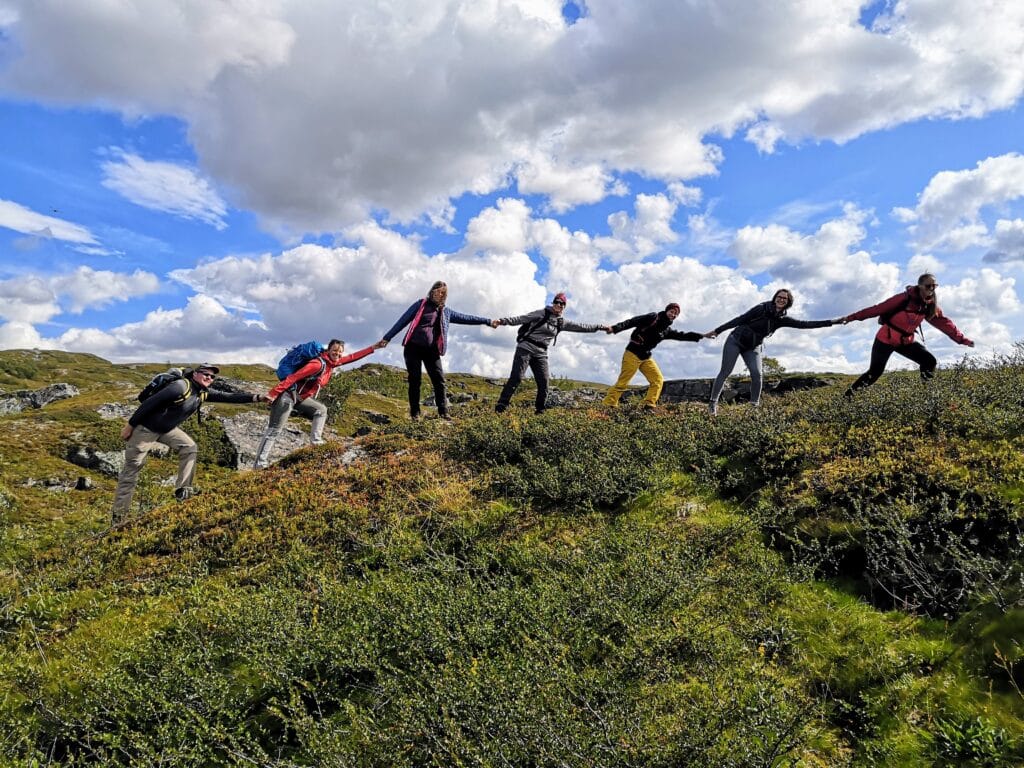 Six people hiking and holding hands.