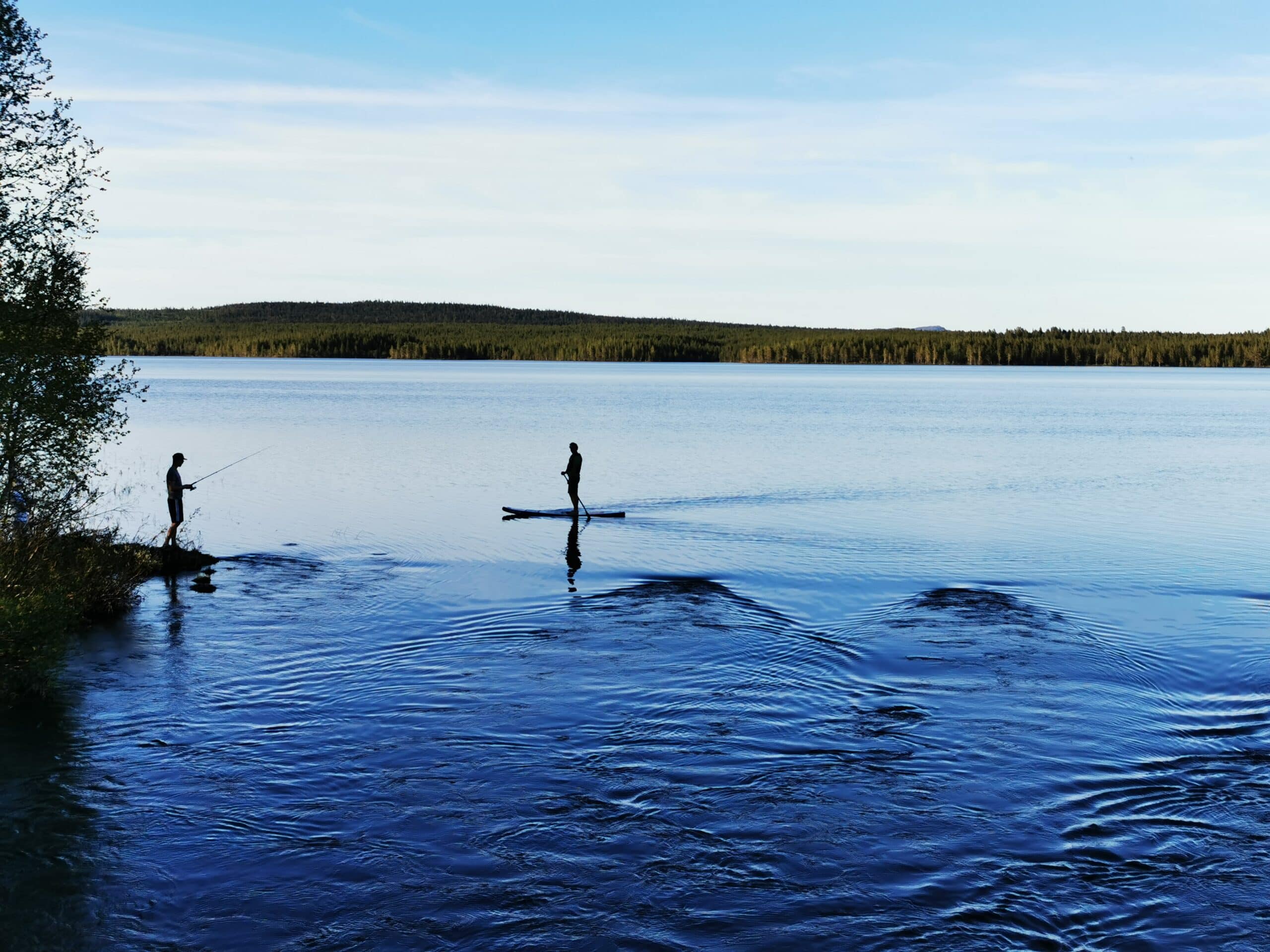 Angeln am ruhigen See bei Sonnenuntergang.