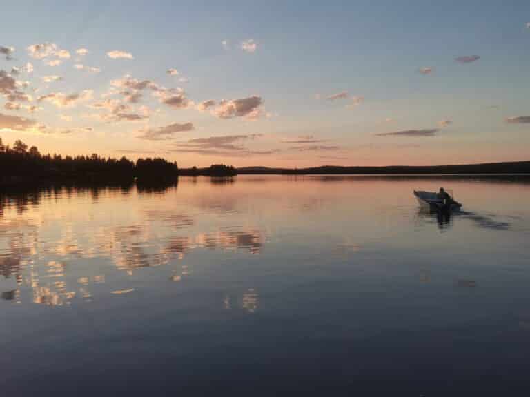 A boat on a calm lake at sunset
