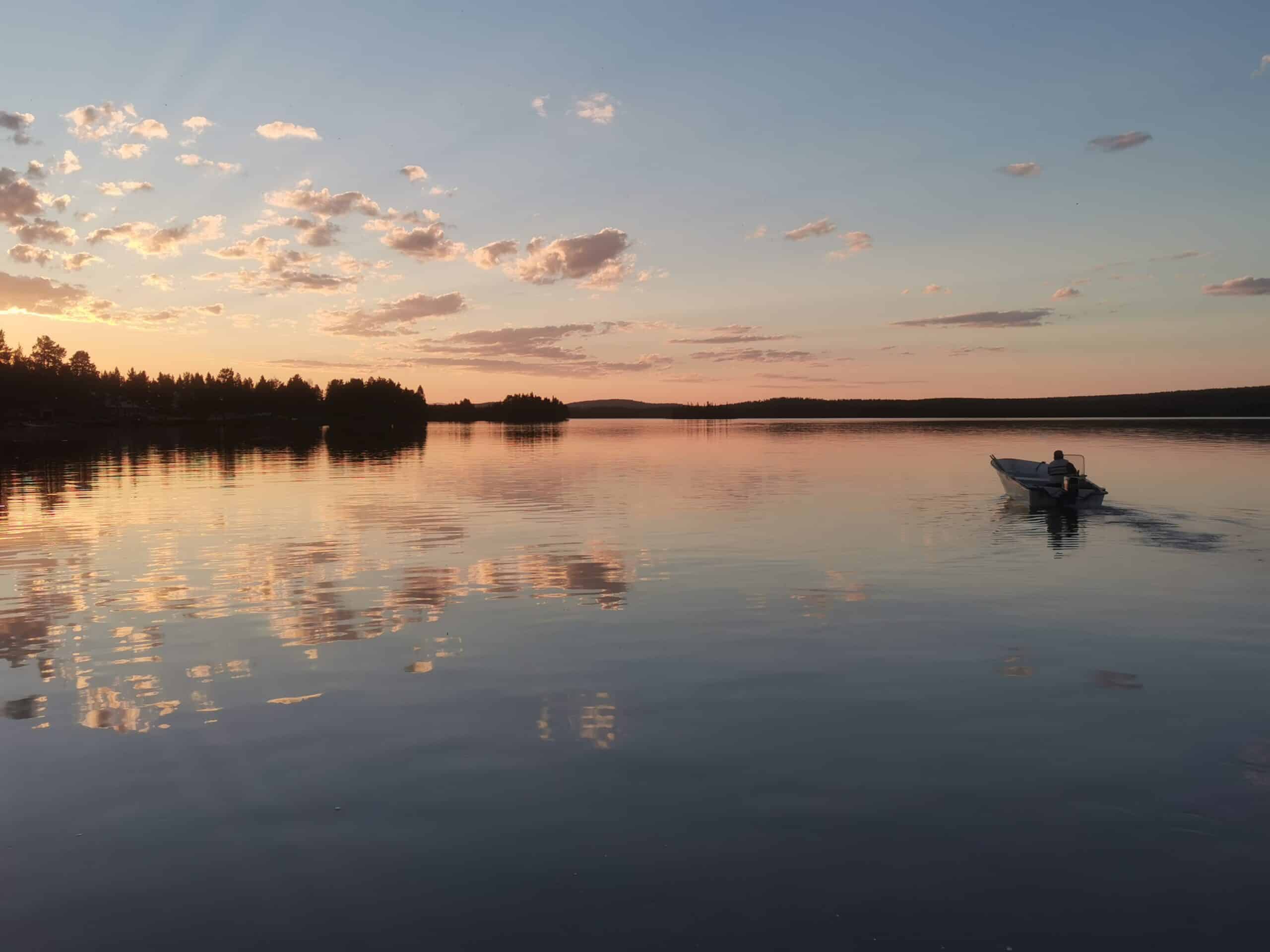 Boot auf ruhigem See bei Sonnenuntergang
