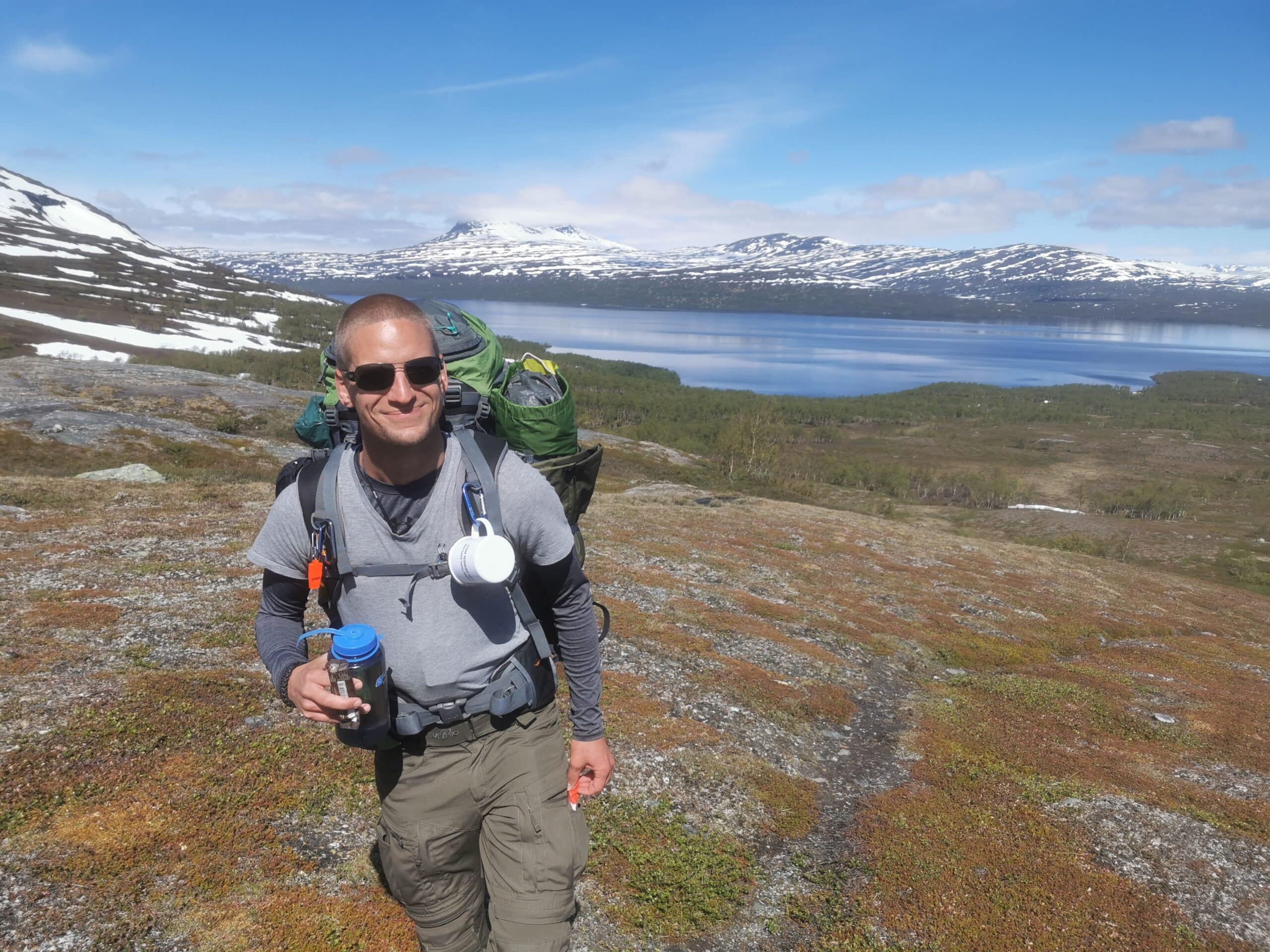 Wanderer mit Rucksack vor atemberaubender Landschaft.