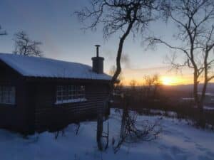 Hütte im Schnee bei Sonnenuntergang