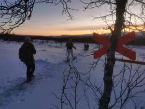 Schneeschuhwanderer bei Sonnenuntergang im Schnee.