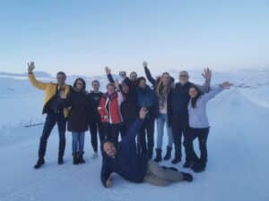 Gruppe Menschen posiert freudig im Schnee.