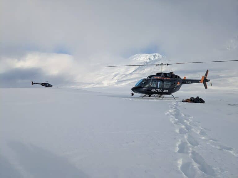 Zwei Hubschrauber im Schnee der Arktis.