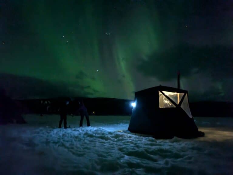 Zelt unter dem Nordlicht auf Schnee.