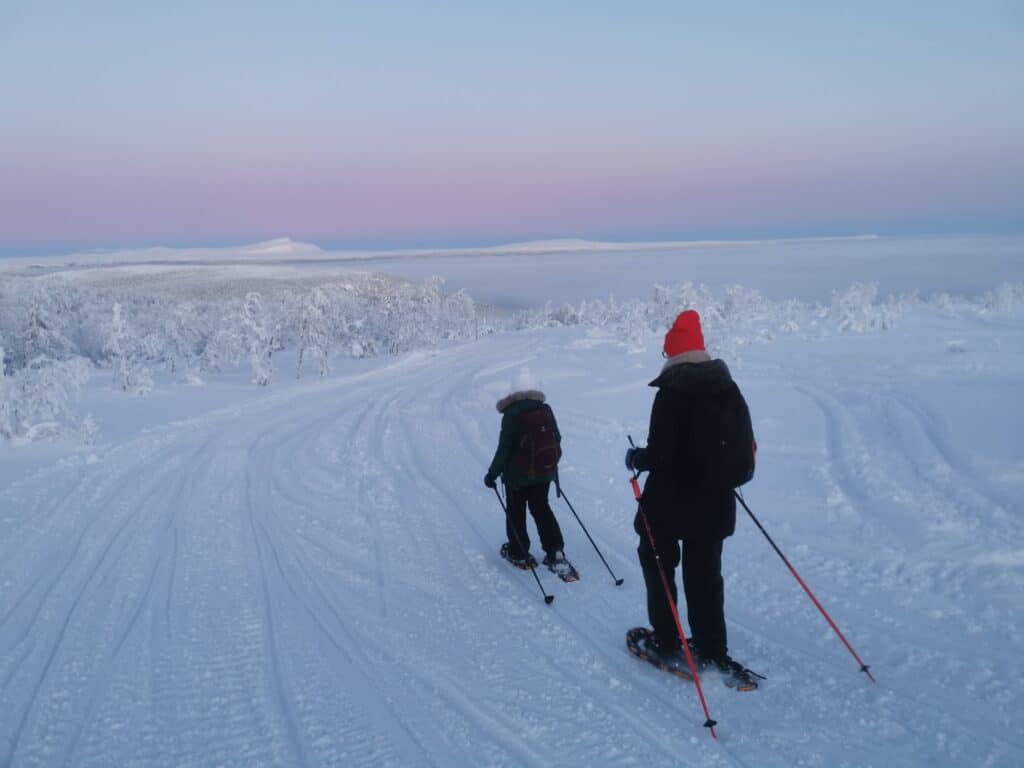 Zwei Personen beim Schneeschuhwandern in Weiß