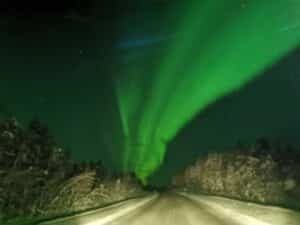 Grüne Nordlichter am Nachthimmel über einer Straße