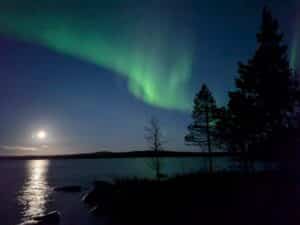 Nachtaufnahme mit Polarlichtern über einem See.