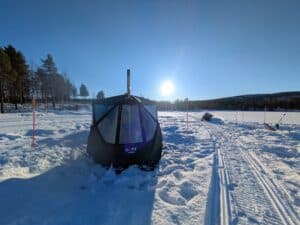 Schneehütte in der sonnigen Winterlandschaft