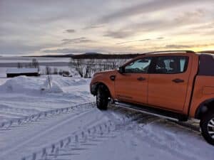 Orange Pickup im Schnee mit Winterlandschaft