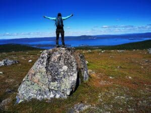 Wanderer auf einem Felsen mit Blick aufs Wasser