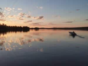 Boot auf ruhigem See während Sonnenuntergang