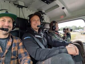 Drei Männer im Hubschrauber, bereit für den Flug.